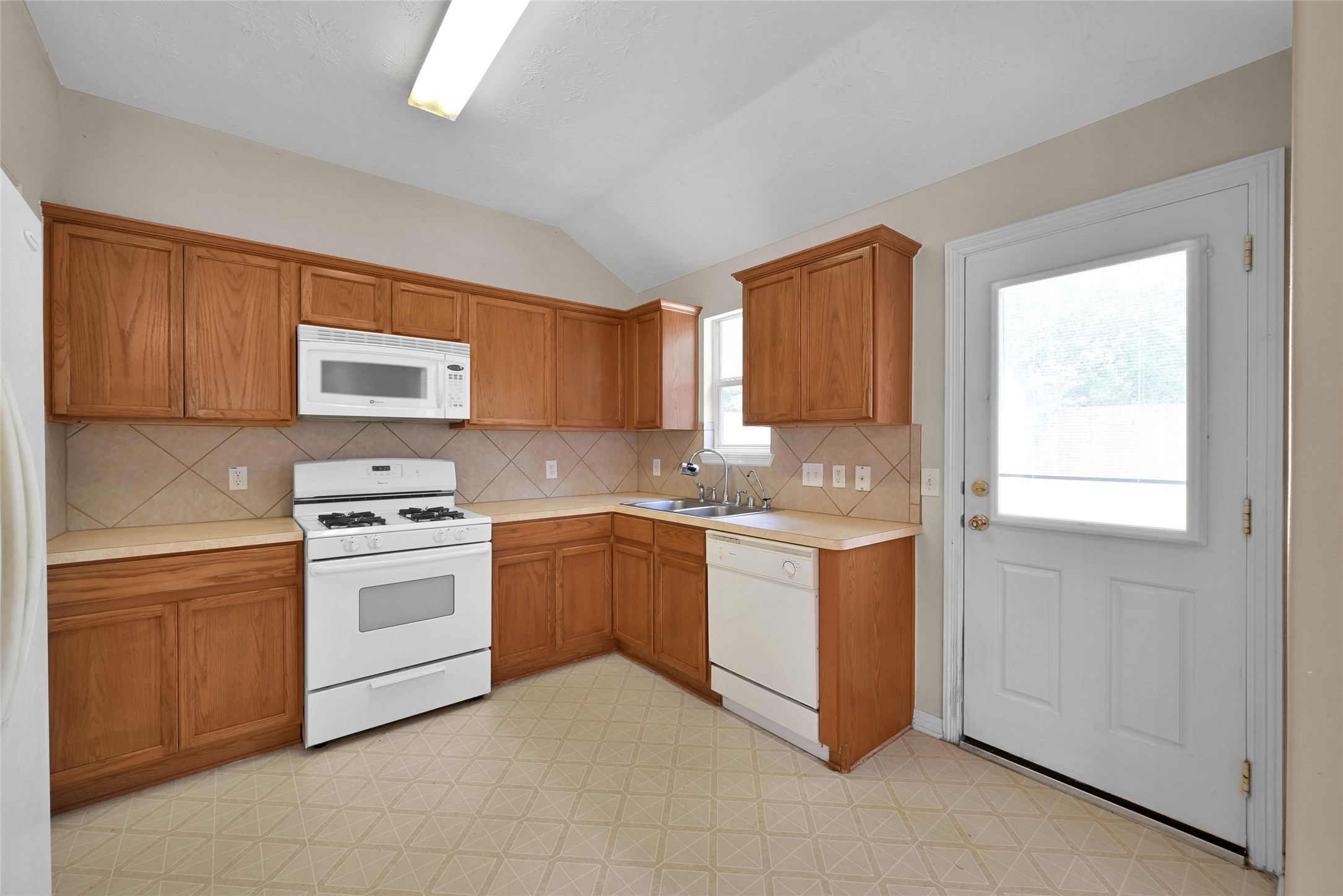 5046 Willow Point Drive Conroe, TX 77303 - Photo 11 of 44 a kitchen with granite countertop white cabinets and white appliances