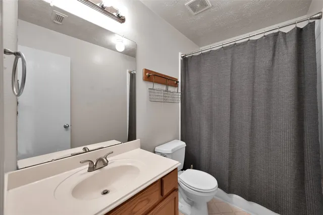 a bathroom with a sink mirror and toilet
