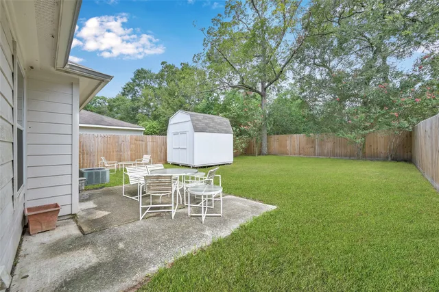 a view of a chair and table in backyard of the house