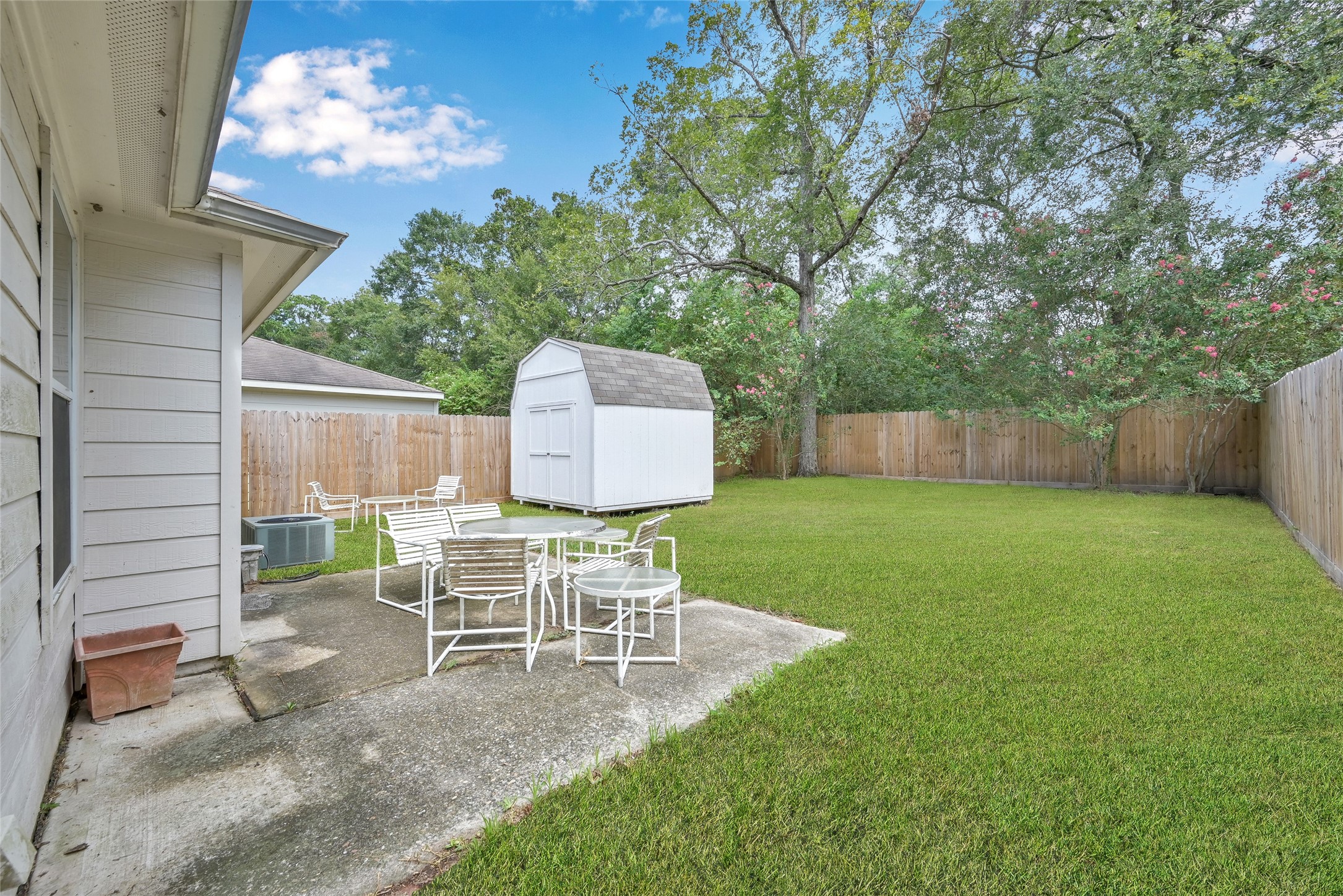 5046 Willow Point Drive Conroe, TX 77303 - Photo 35 of 44 a view of a chair and table in backyard of the house