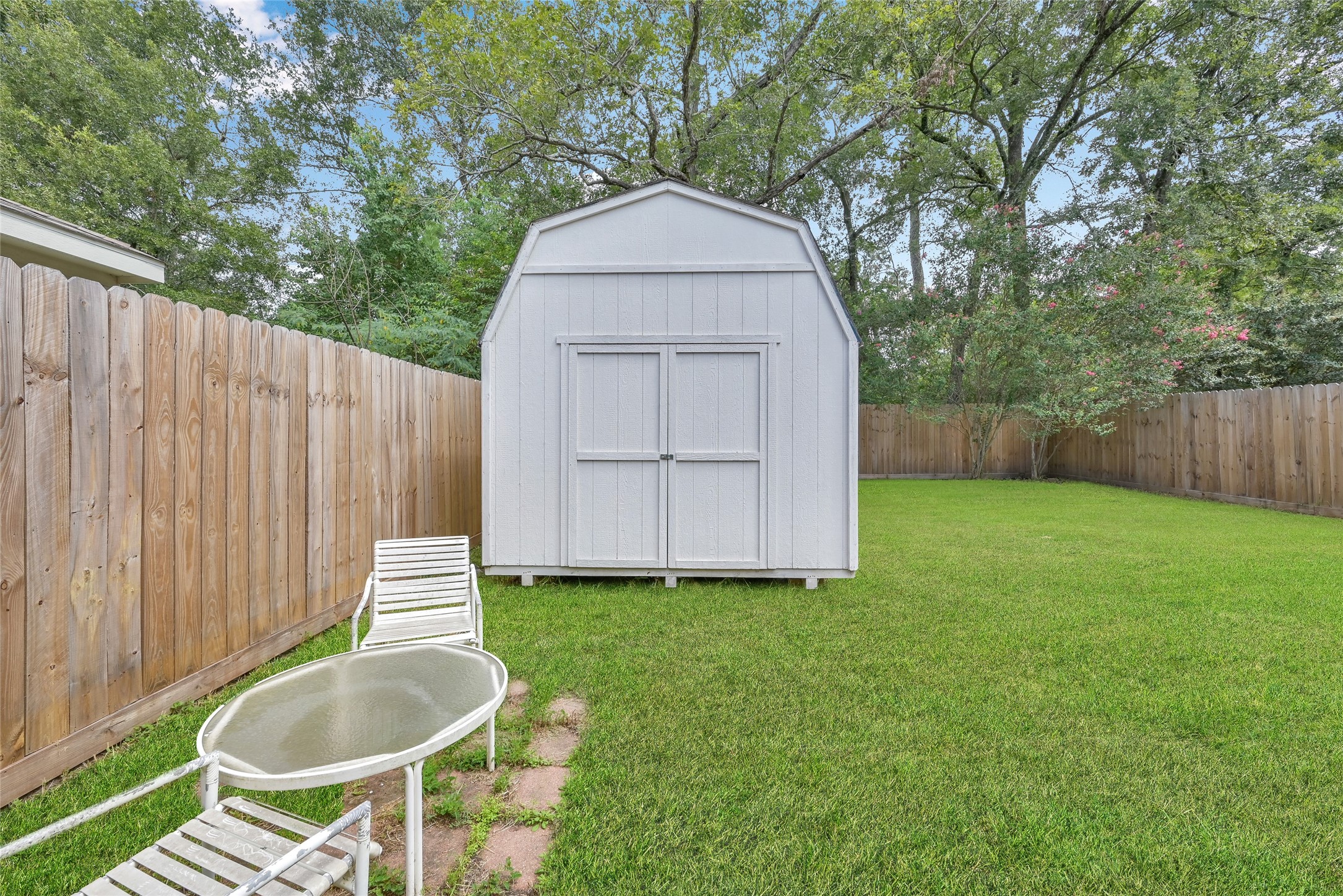 5046 Willow Point Drive Conroe, TX 77303 - Photo 36 of 44 a backyard of a house with table and chairs