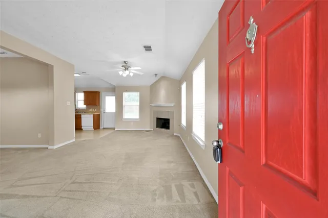 a view of an empty room with a fireplace and a window