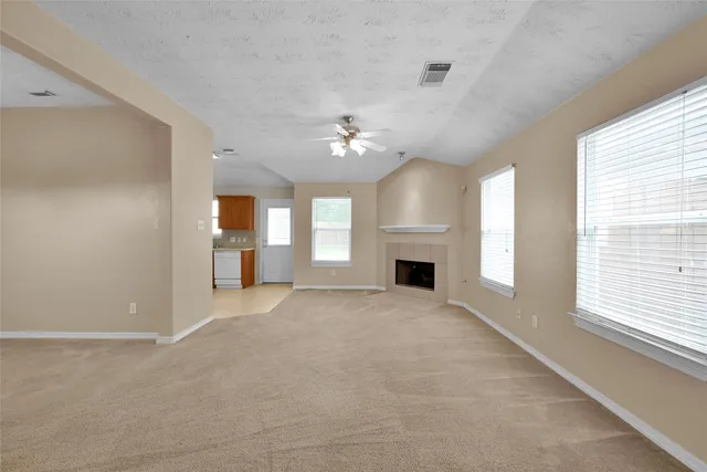 a view of an empty room with a fireplace and a window