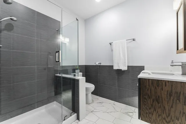 a bathroom with a sink a toilet and shower