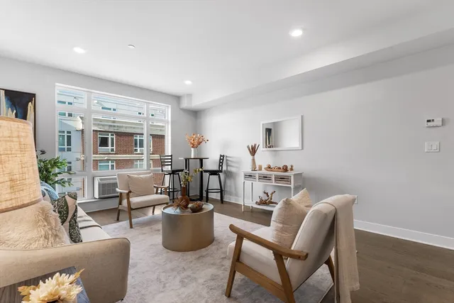 a living room with furniture a rug and a window