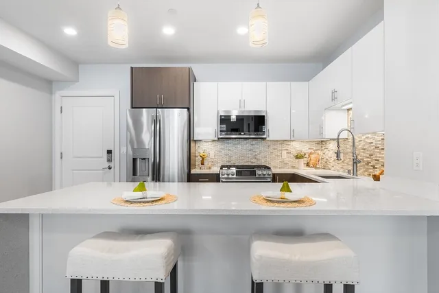 a kitchen with a sink a stove and chairs