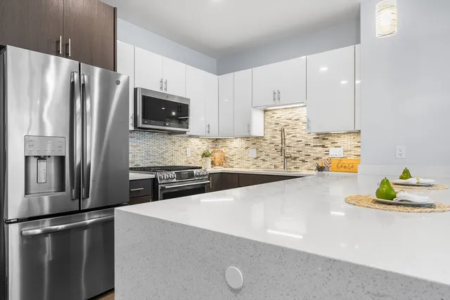 a kitchen with stainless steel appliances a refrigerator sink and microwave