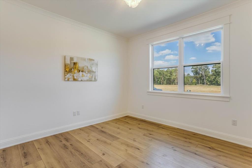 242 Private Road Mount Pleasant, TX 75455 - Photo 34 of 40 Crown molding, wood-finish flooring, white trim, recessed window, and white walls