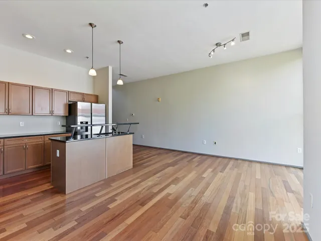 a kitchen with granite countertop a stove a sink and a wooden floors