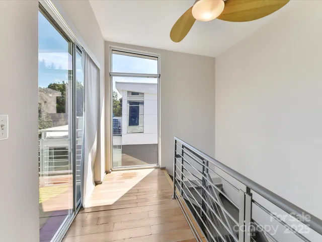a view of a hallway with wooden floor and a floor to ceiling window