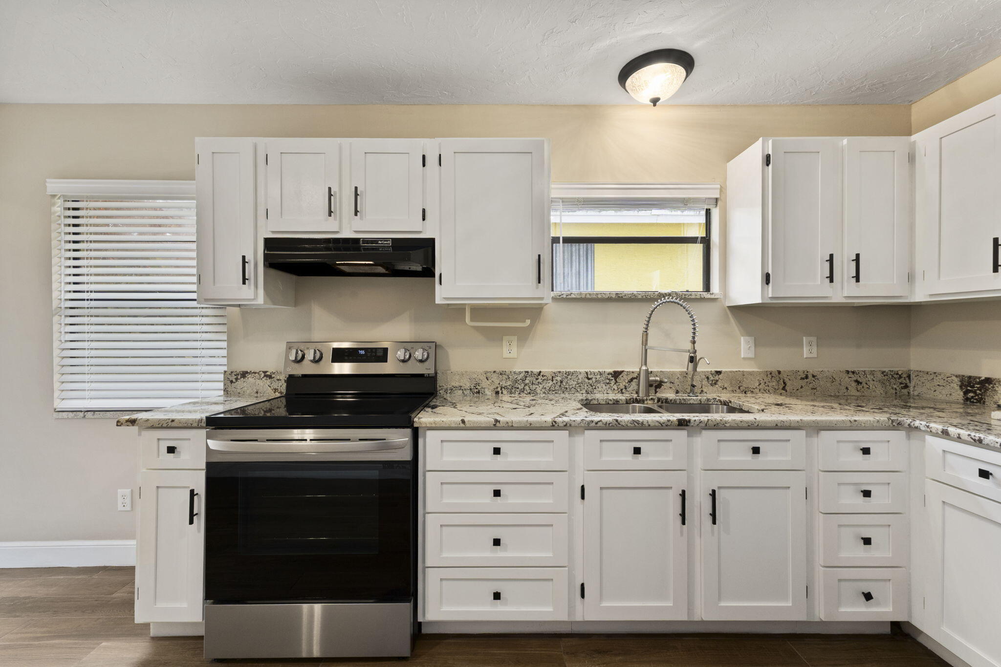 3585 Southeast 8th Street Okeechobee, FL 34974 - Photo 13 of 39 a kitchen with granite countertop white cabinets and stainless steel appliances