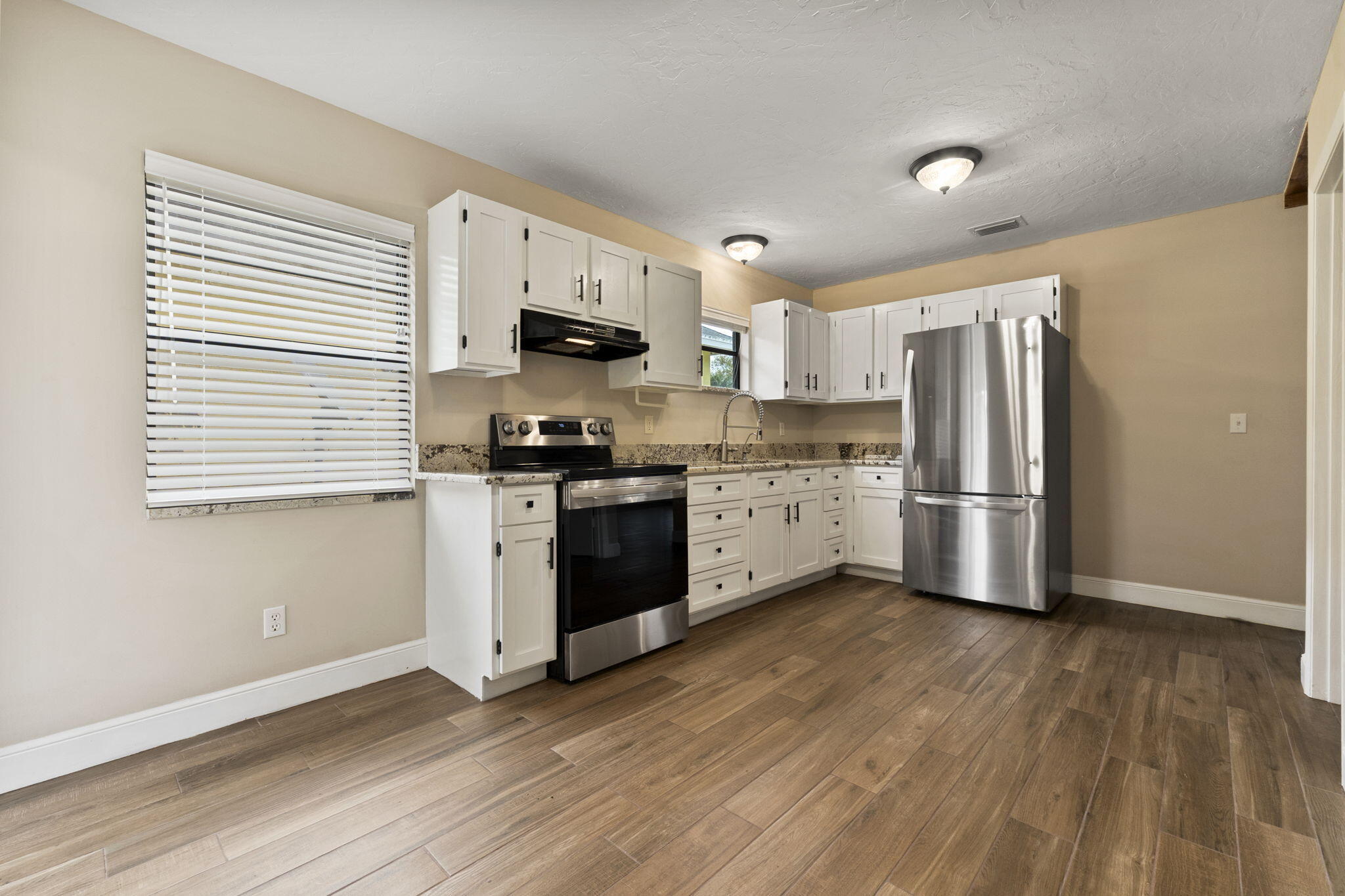 3585 Southeast 8th Street Okeechobee, FL 34974 - Photo 14 of 39 a kitchen with stainless steel appliances a refrigerator sink and cabinets