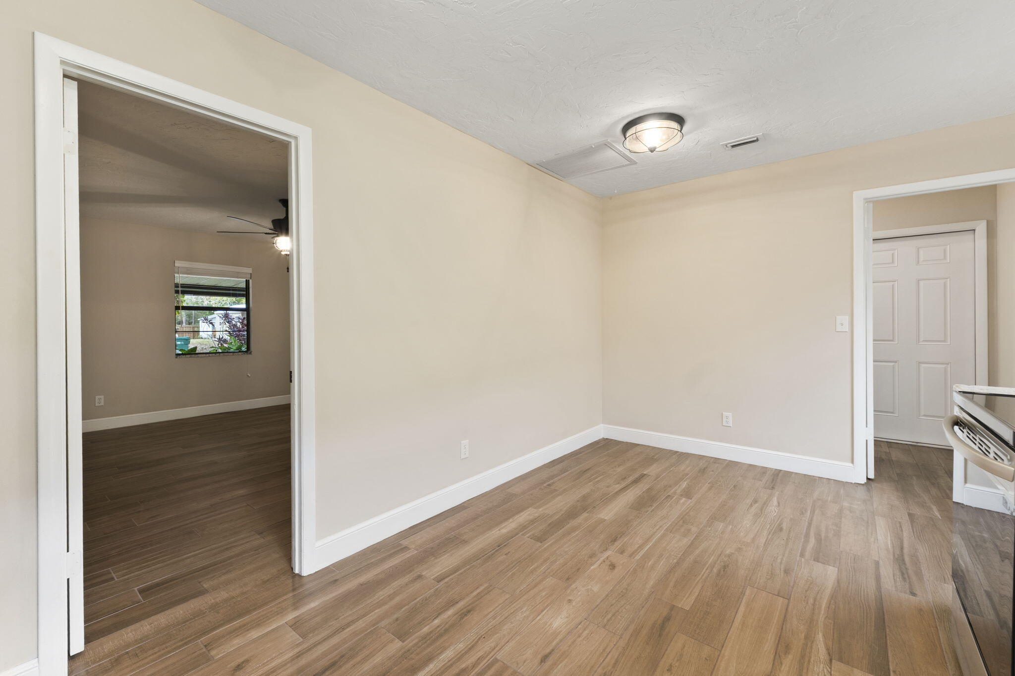 3585 Southeast 8th Street Okeechobee, FL 34974 - Photo 16 of 39 an empty room with wooden floor and windows