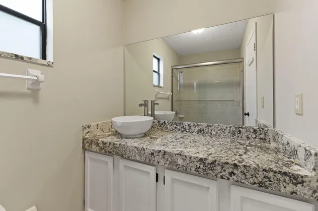 a bathroom with a granite countertop sink and a mirror