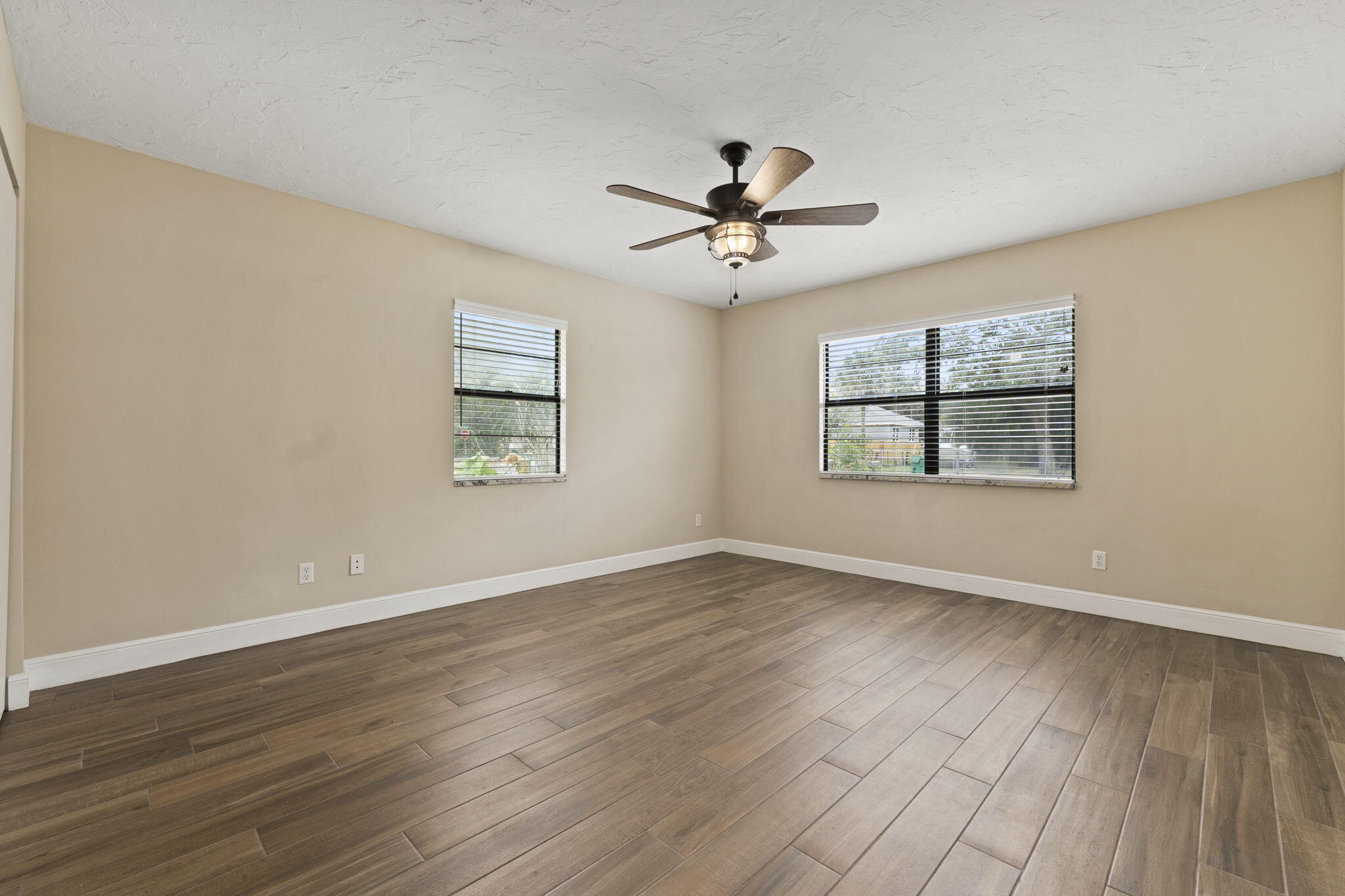 3585 Southeast 8th Street Okeechobee, FL 34974 - Photo 24 of 39 a view of empty room with wooden floor and fan