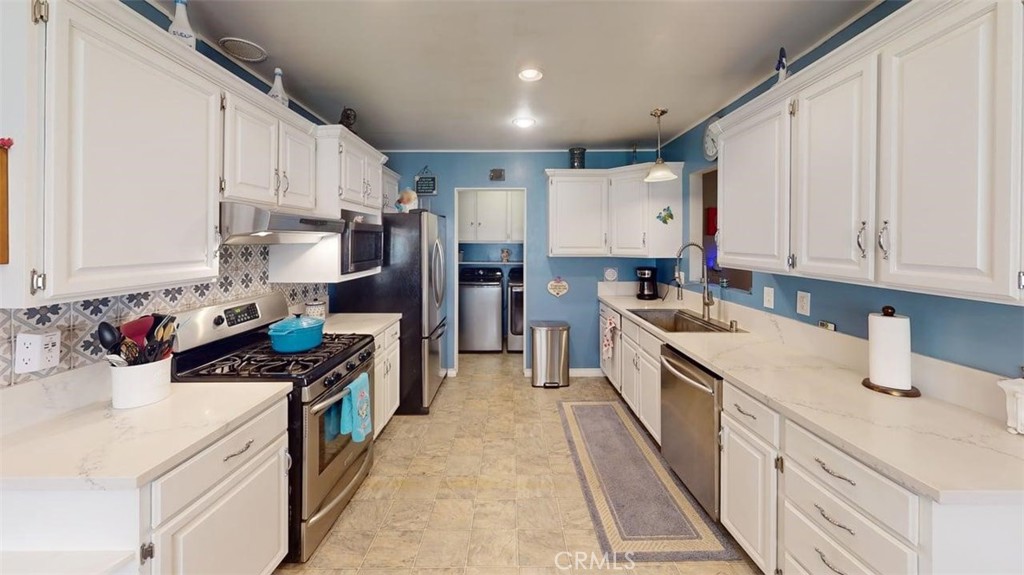7450 Thunderbird Lane Stanton, CA 90680 - Photo 6 of 31 a kitchen with stainless steel appliances a stove a sink a refrigerator and cabinets