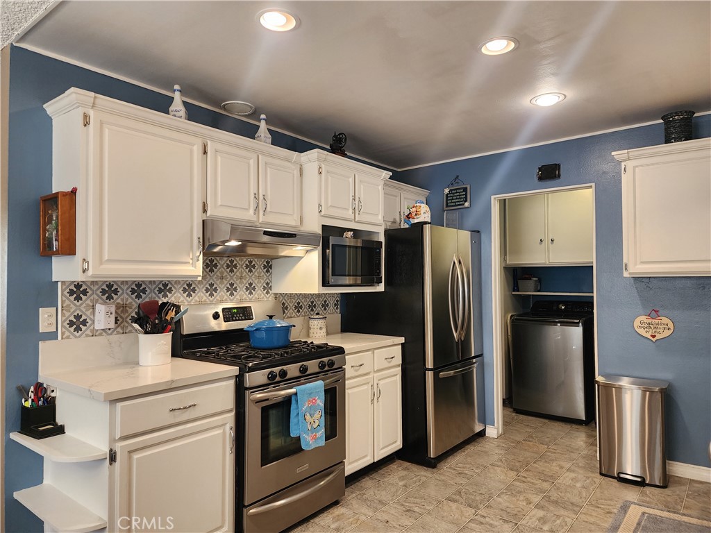 7450 Thunderbird Lane Stanton, CA 90680 - Photo 8 of 31 a kitchen with stainless steel appliances a stove a refrigerator and a sink