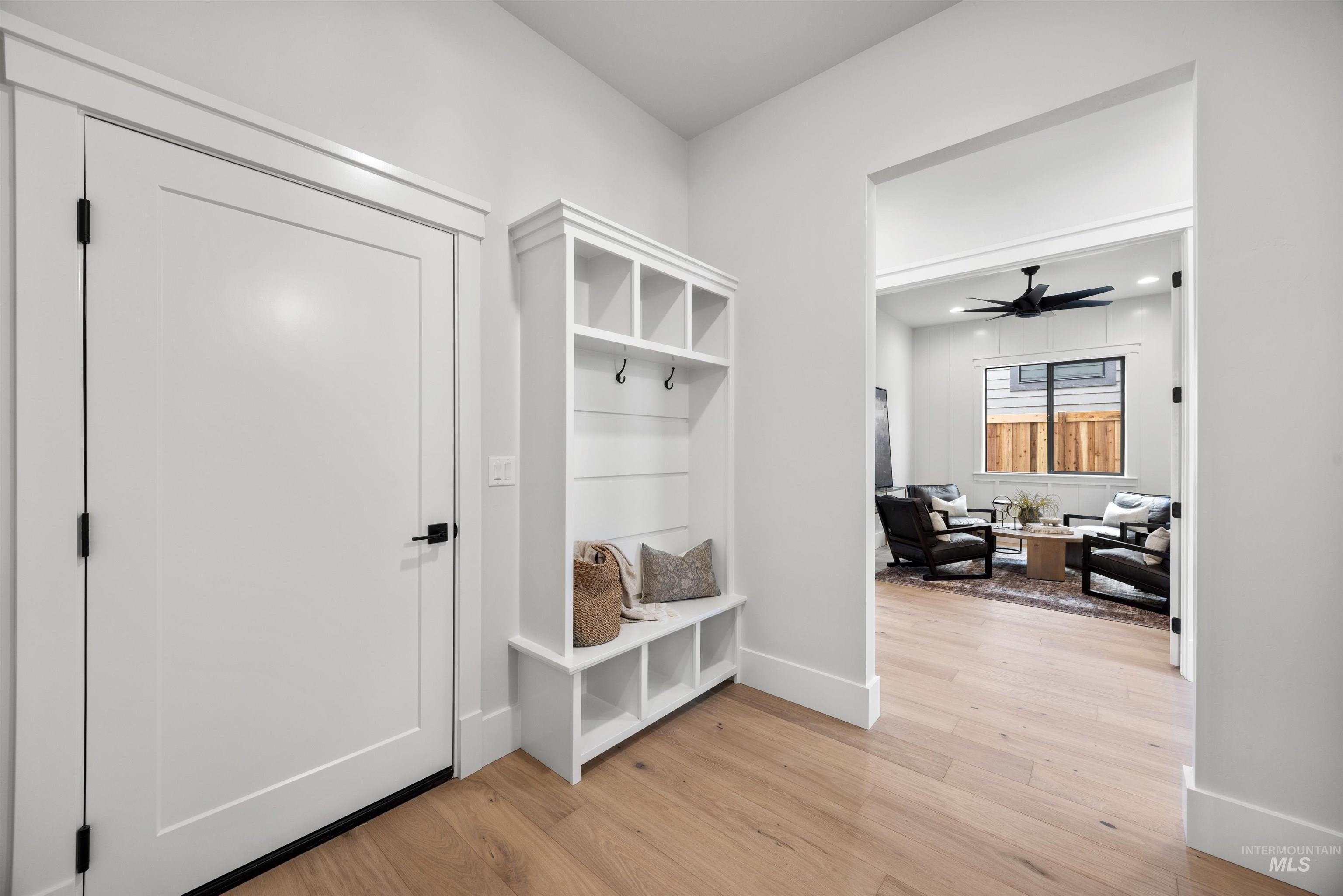 5940 South Pinpoint Way Meridian, ID 83642 - Photo 36 of 40 Hardwood-finish flooring, built-in storage bench, modern flat-panel door, recessed lighting, and a contemporary ceiling fan