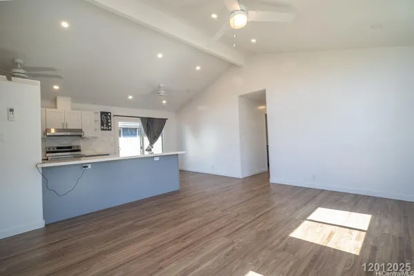 a large kitchen with a wooden floor and stainless steel appliances