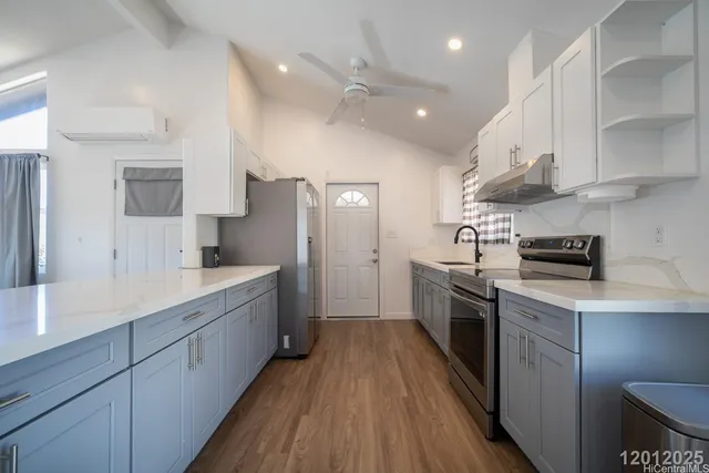 a large kitchen with stainless steel appliances sink a refrigerator and cabinets