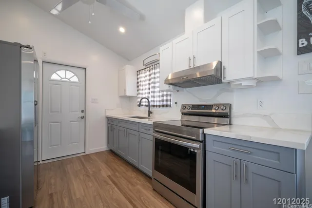 a kitchen with cabinets wooden floor and stainless steel appliances