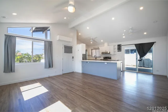 a large kitchen with stainless steel appliances kitchen island a large counter top and a wooden floors