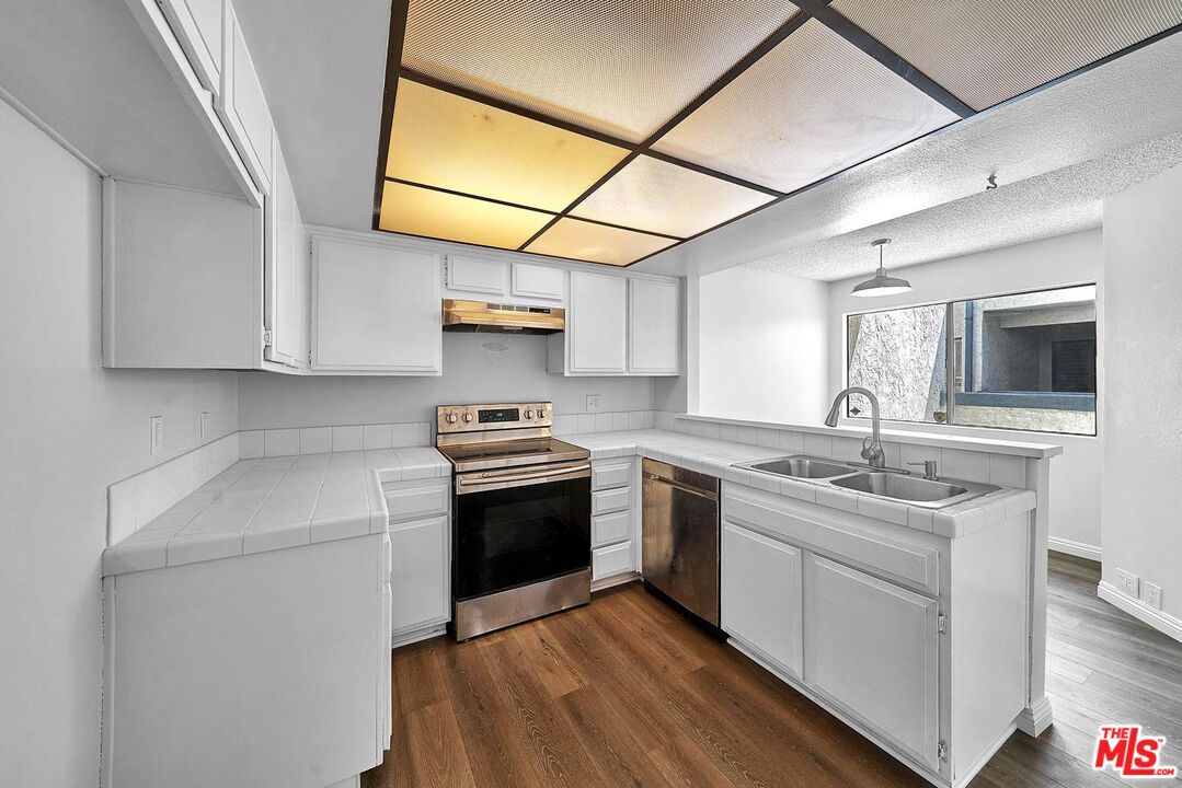 1333 Valley View Road, Unit 25 Glendale, CA 91202 - Photo 12 of 27 a kitchen with stainless steel appliances granite countertop a sink stove and microwave