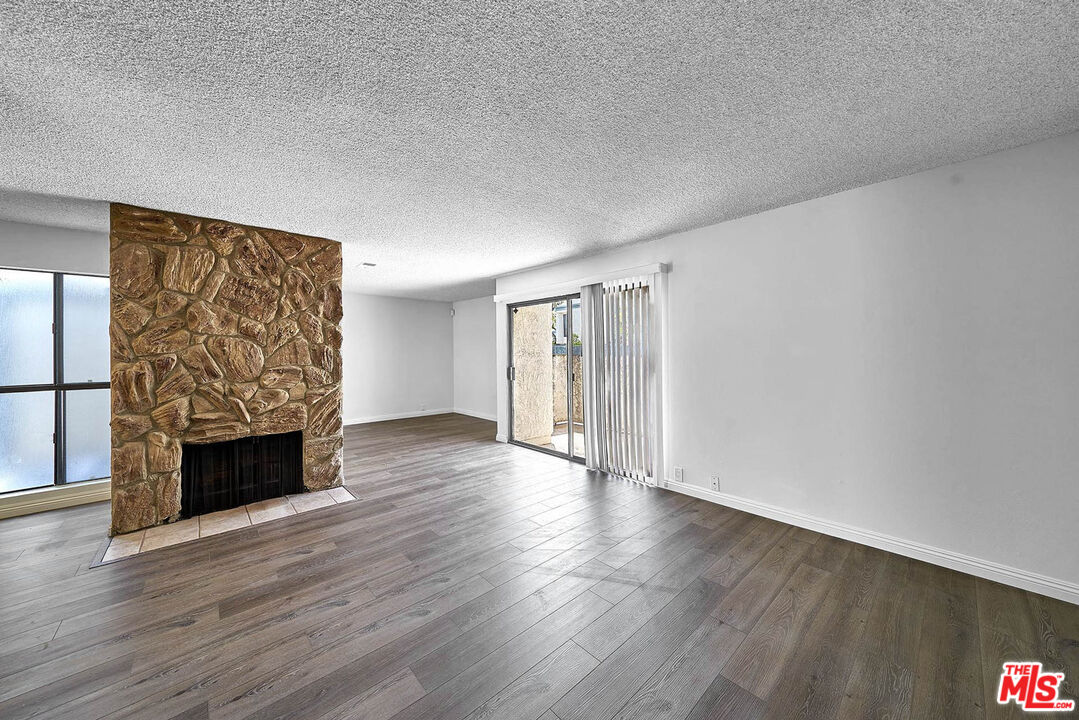 1333 Valley View Road, Unit 25 Glendale, CA 91202 - Photo 3 of 27 a view of an empty room with wooden floor fireplace and a window