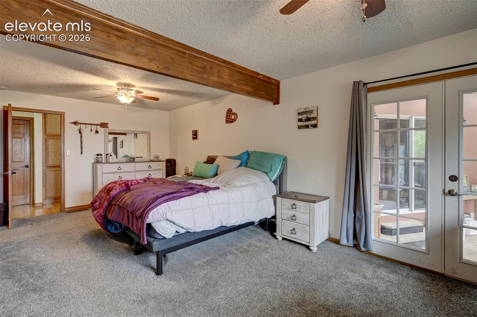 8170 Valli Farm Road Fountain, CO 80817 - Photo 15 of 50 Carpeted room with exposed wood beam, ceiling fan with light fixture, and French doors