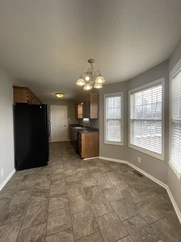 a large kitchen with a stove a refrigerator and a cabinets