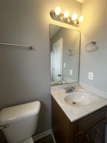 a bathroom with a sink mirror vanity and toilet