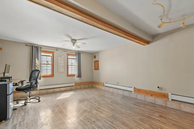 a view of a livingroom with workspace and a window