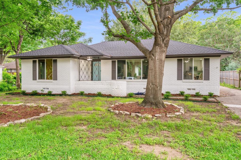 4815 Kelman Street Dallas, TX 75214 - Photo 32 of 37 White painted brick exterior with dark shutters and a dark shingle roof