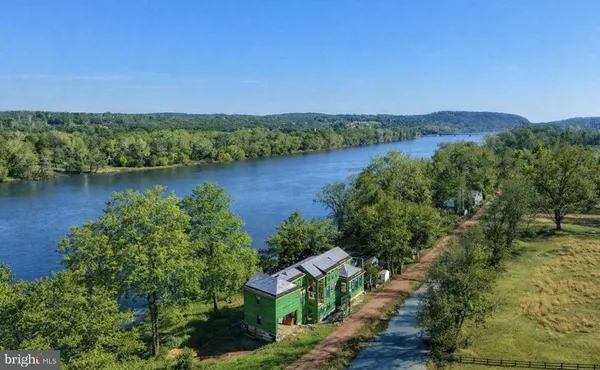 an aerial view of a house with a yard and lake view