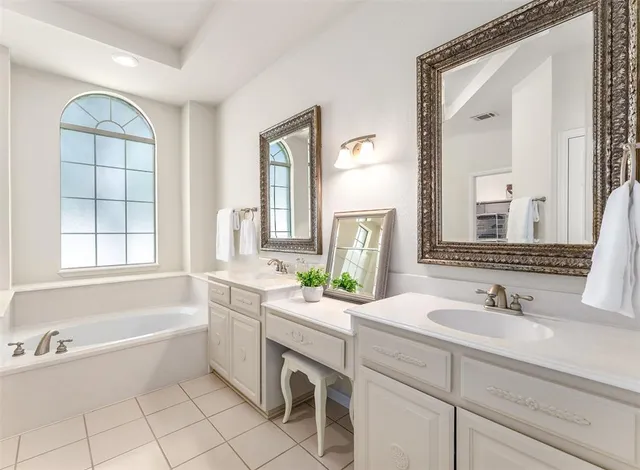 a spacious bathroom with a tub shower and a sink