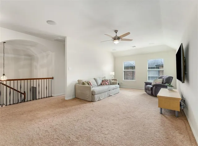 a bedroom with a large bed and a chandelier fan