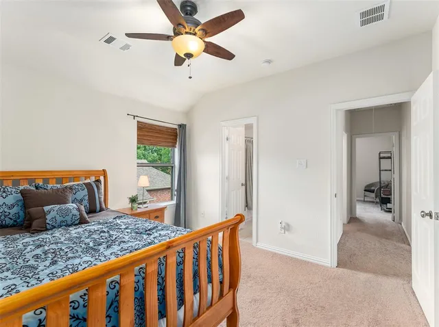 a bedroom with a bed and a ceiling fan