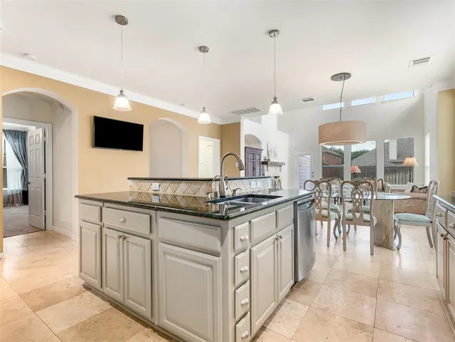 a kitchen with stainless steel appliances granite countertop a sink a stove and a wooden floors