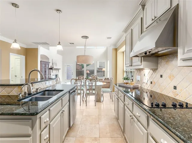 a kitchen with stainless steel appliances granite countertop a sink and a refrigerator
