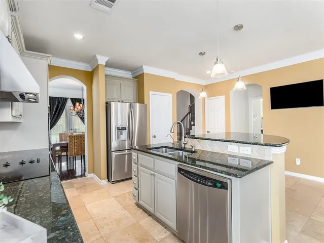 a kitchen with granite countertop a sink stainless steel appliances and cabinets