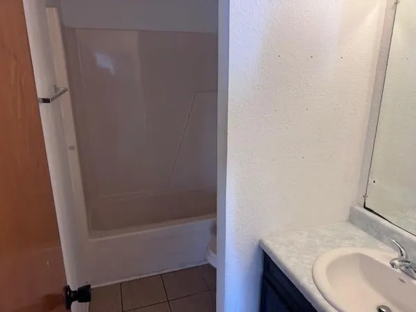 a white toilet sitting next to a bath tub