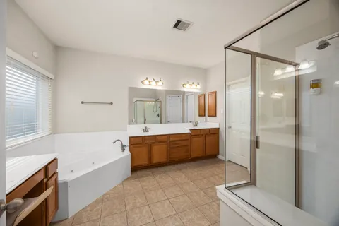 a large bathroom with a tub shower sink granite and a mirror