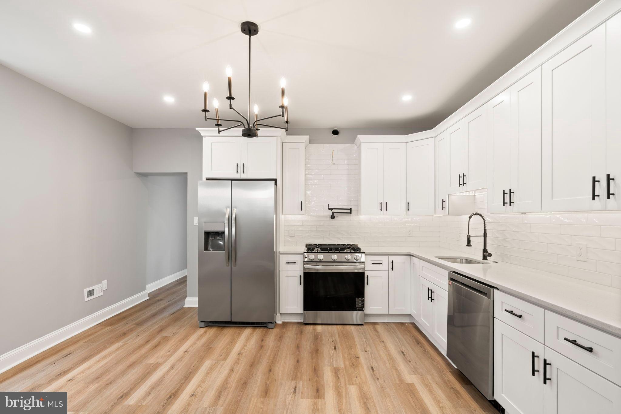 3464 Division Street Philadelphia, PA 19129 - Photo 11 of 40 a kitchen with stainless steel appliances granite countertop a sink stove and refrigerator