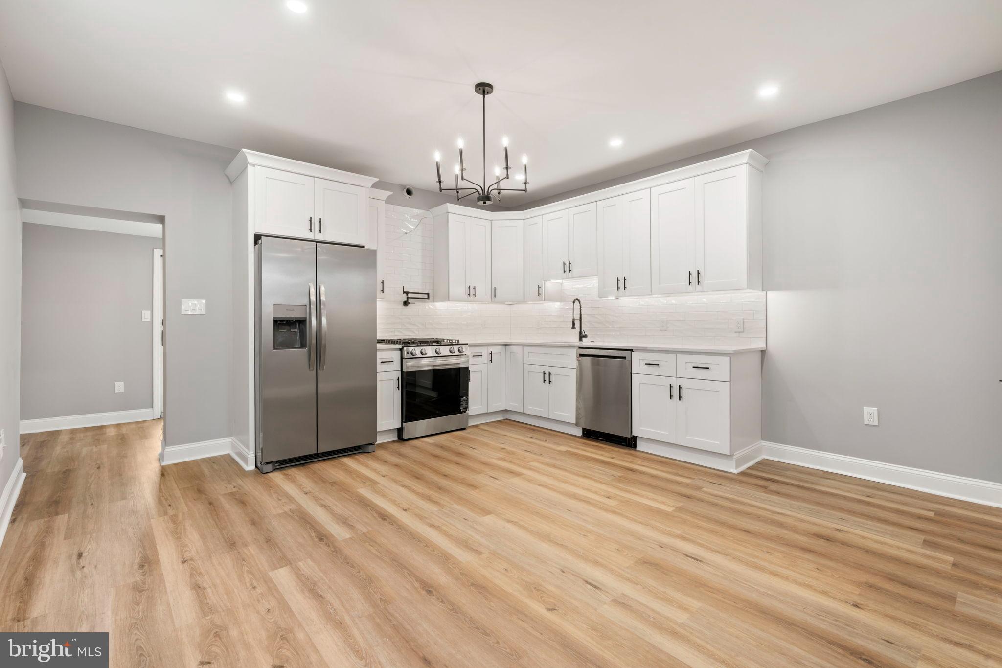 3464 Division Street Philadelphia, PA 19129 - Photo 12 of 40 a kitchen with stainless steel appliances kitchen island a refrigerator sink and cabinets