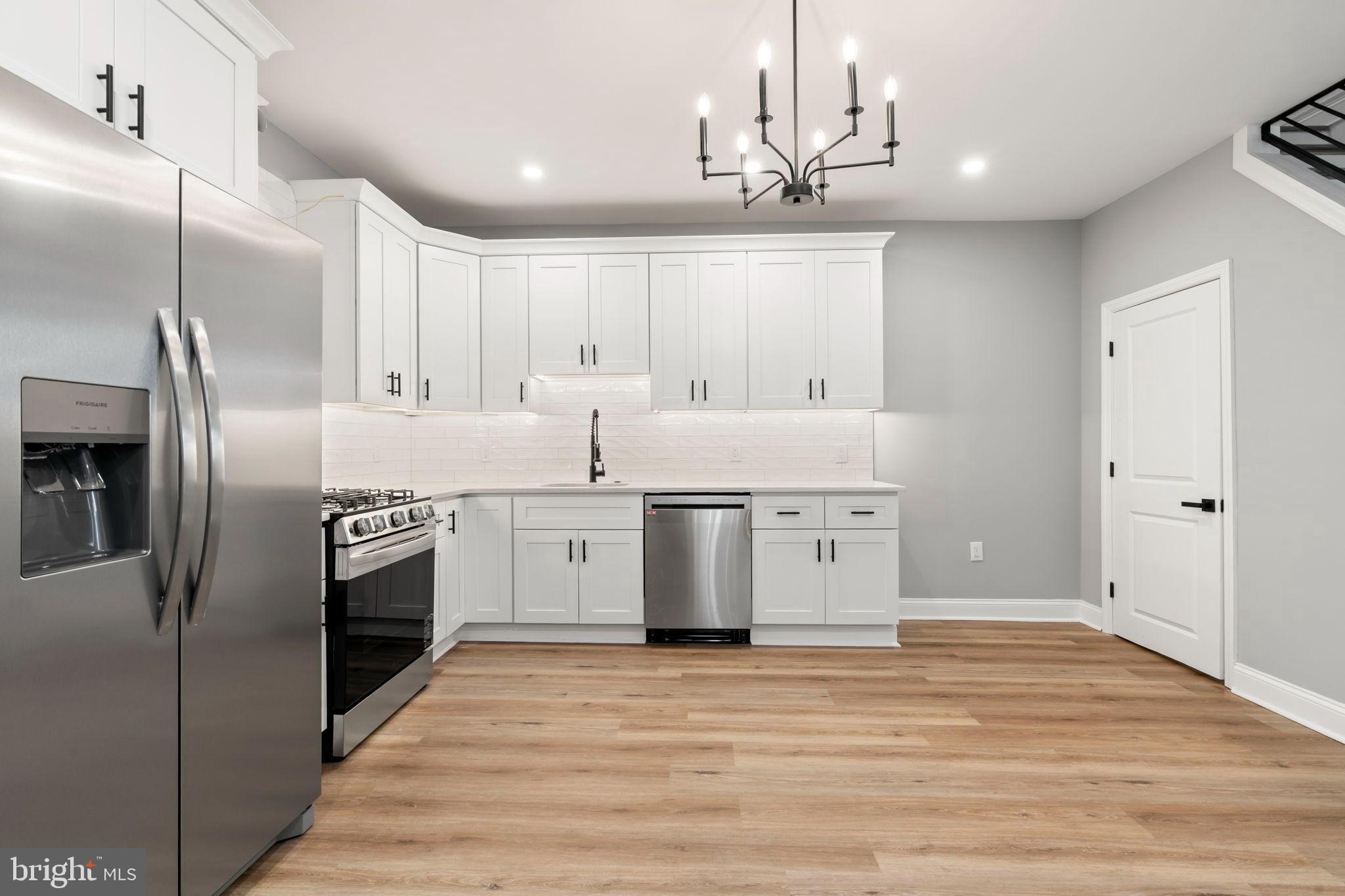 3464 Division Street Philadelphia, PA 19129 - Photo 10 of 40 a kitchen with stainless steel appliances kitchen island granite countertop a refrigerator and a sink