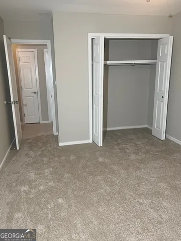 an empty room with closet and wooden floor