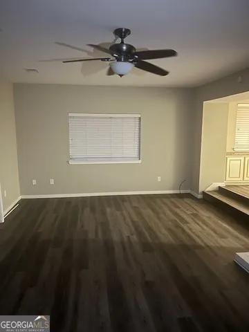 a view of a room with wooden floor and fan