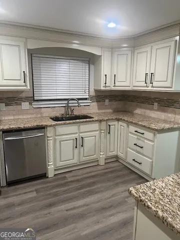 a kitchen with granite countertop white cabinets and white appliances