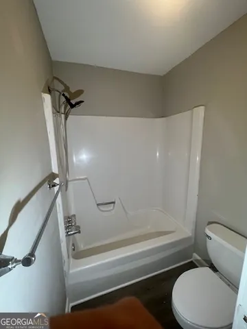 a bathroom with a toilet and a shower