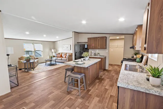 a large kitchen with lots of counter top space a sink stainless steel appliances and cabinets